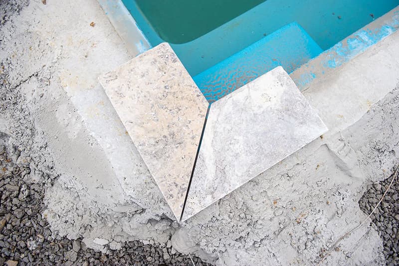 Installing coping on a Leisure Pools fiberglass swimming pool