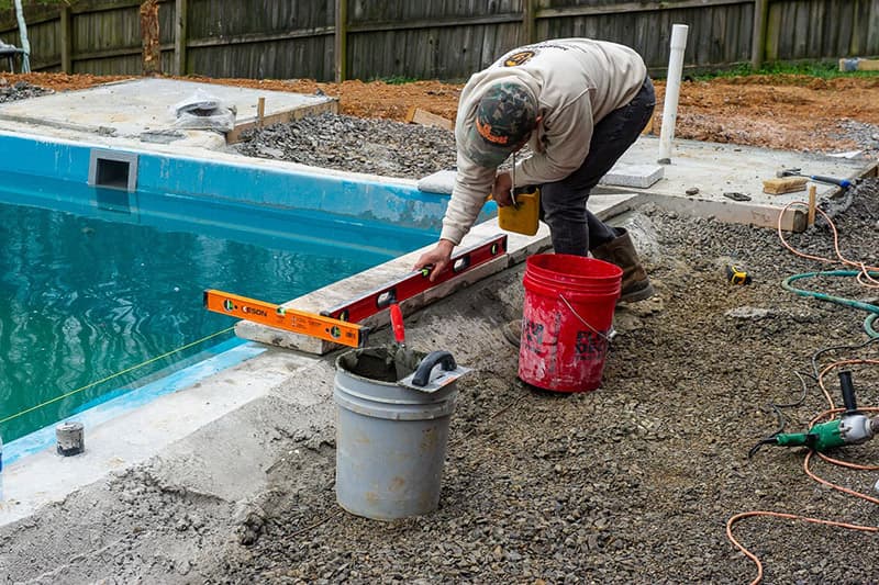 Installing coping on a Leisure Pools fiberglass swimming pool