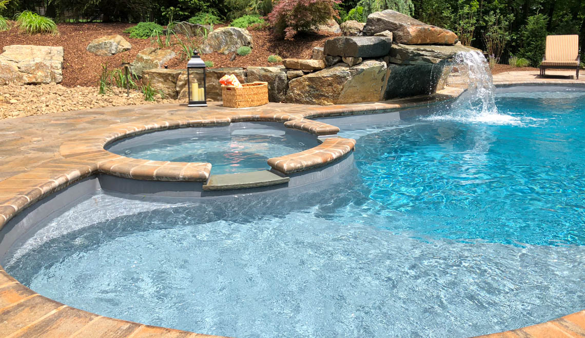 Leisure Pools Allure large freeform swimming pool with built-in spa and splash deck