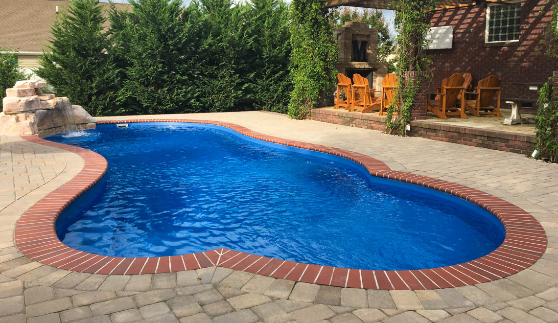 Leisure Pools Eclipse freeform fiberglass swimming pool with built-in splash deck