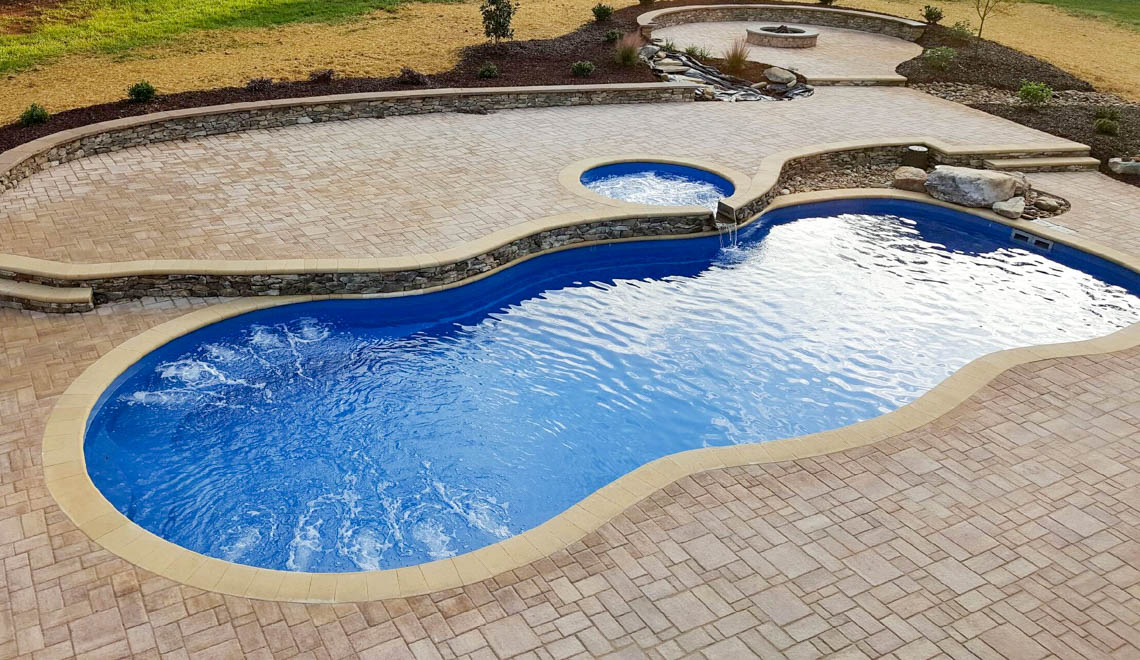 Leisure Pools Mediterranean large freeform swimming pool with wrap-around bench