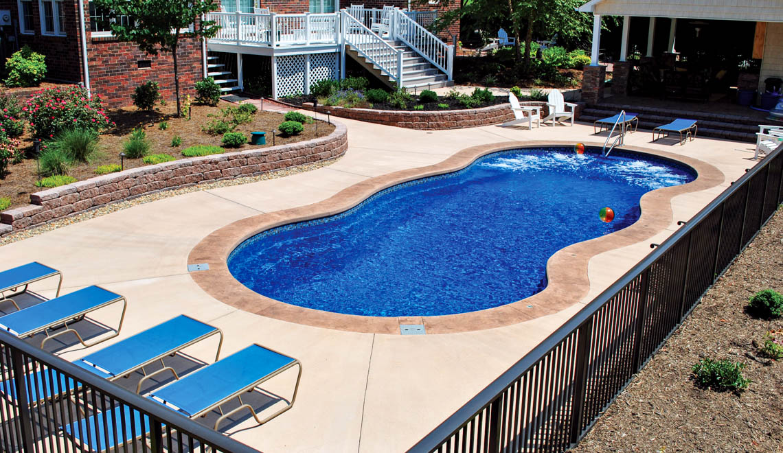 Leisure Pools Mediterranean fiberglass freeform swimming pool with wrap-around bench