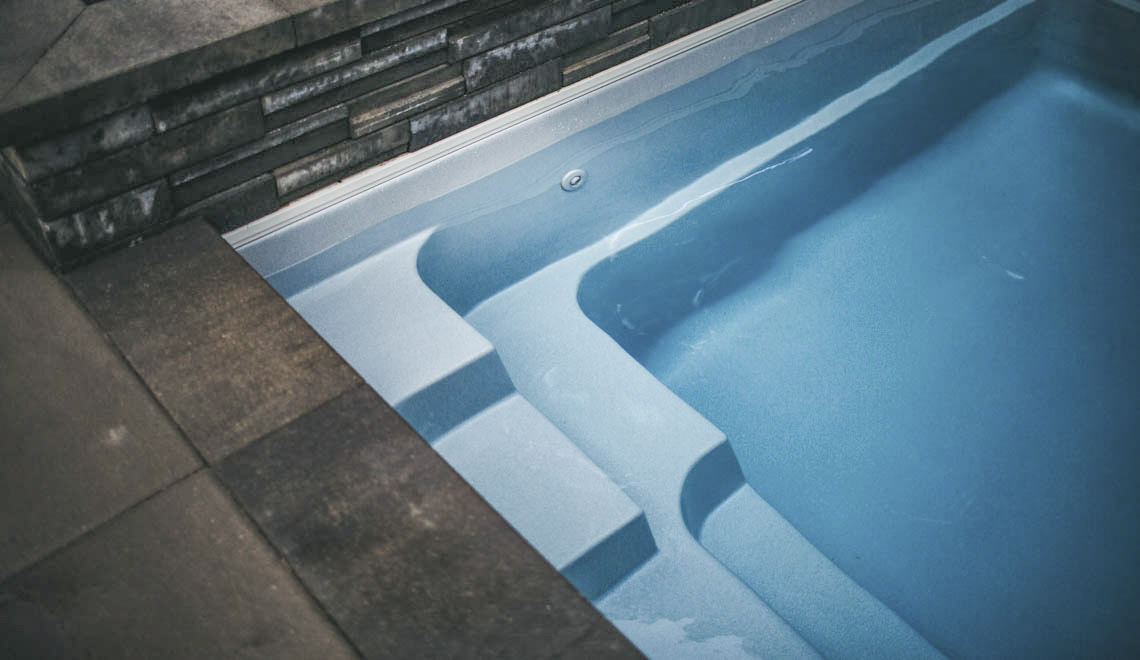 Leisure Pools Reflection composite fiberglass swimming pool with full-length bench seat
