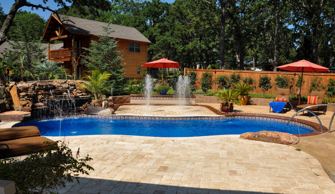 Leisure Pools Riviera composite fiberglass freeform swimming pool with wrapped bench seat
