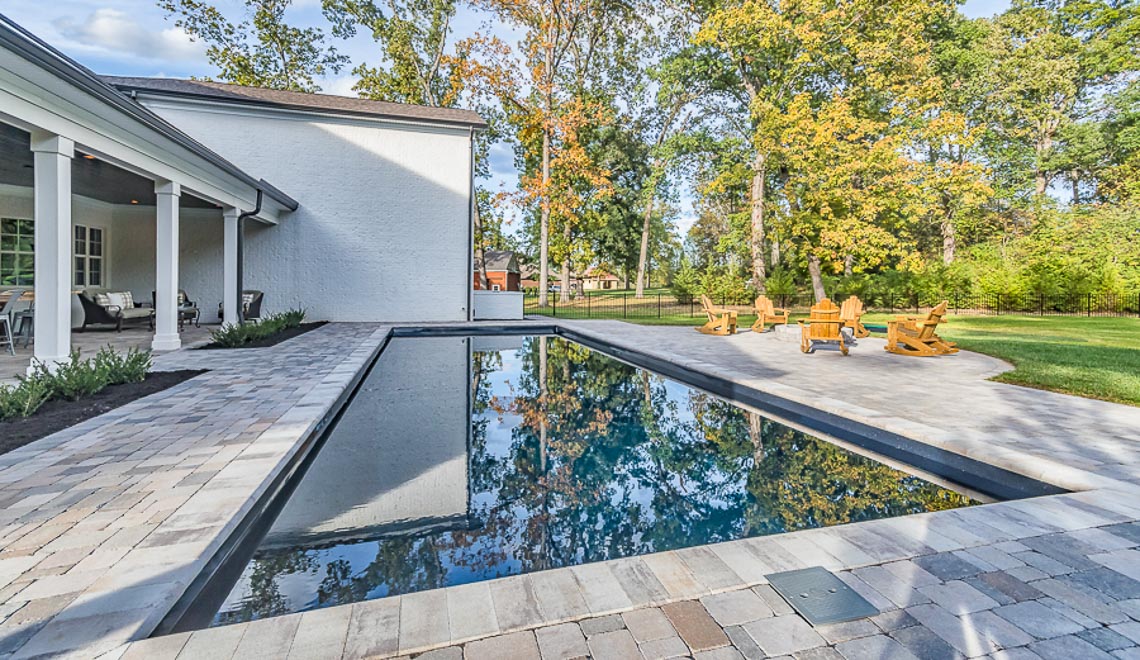 Leisure Pools Infinity large precast fiberglass swimming pool with built-in steps and bench