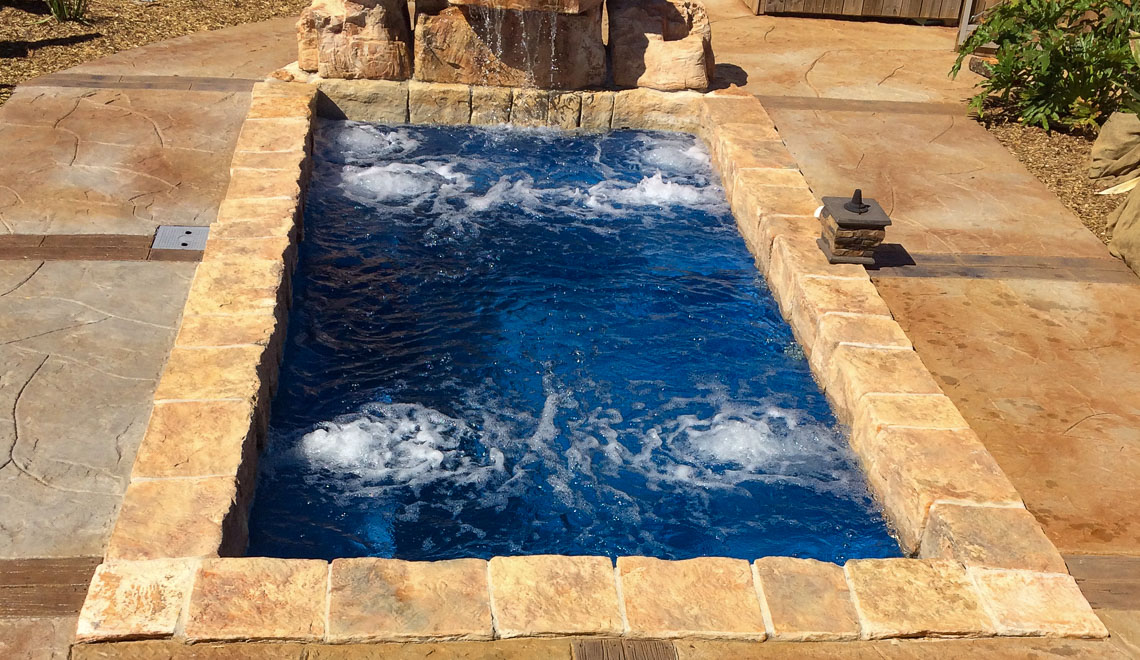 Leisure Pools Palladium Plunge fiberglass swimming pool with wrapped bench area