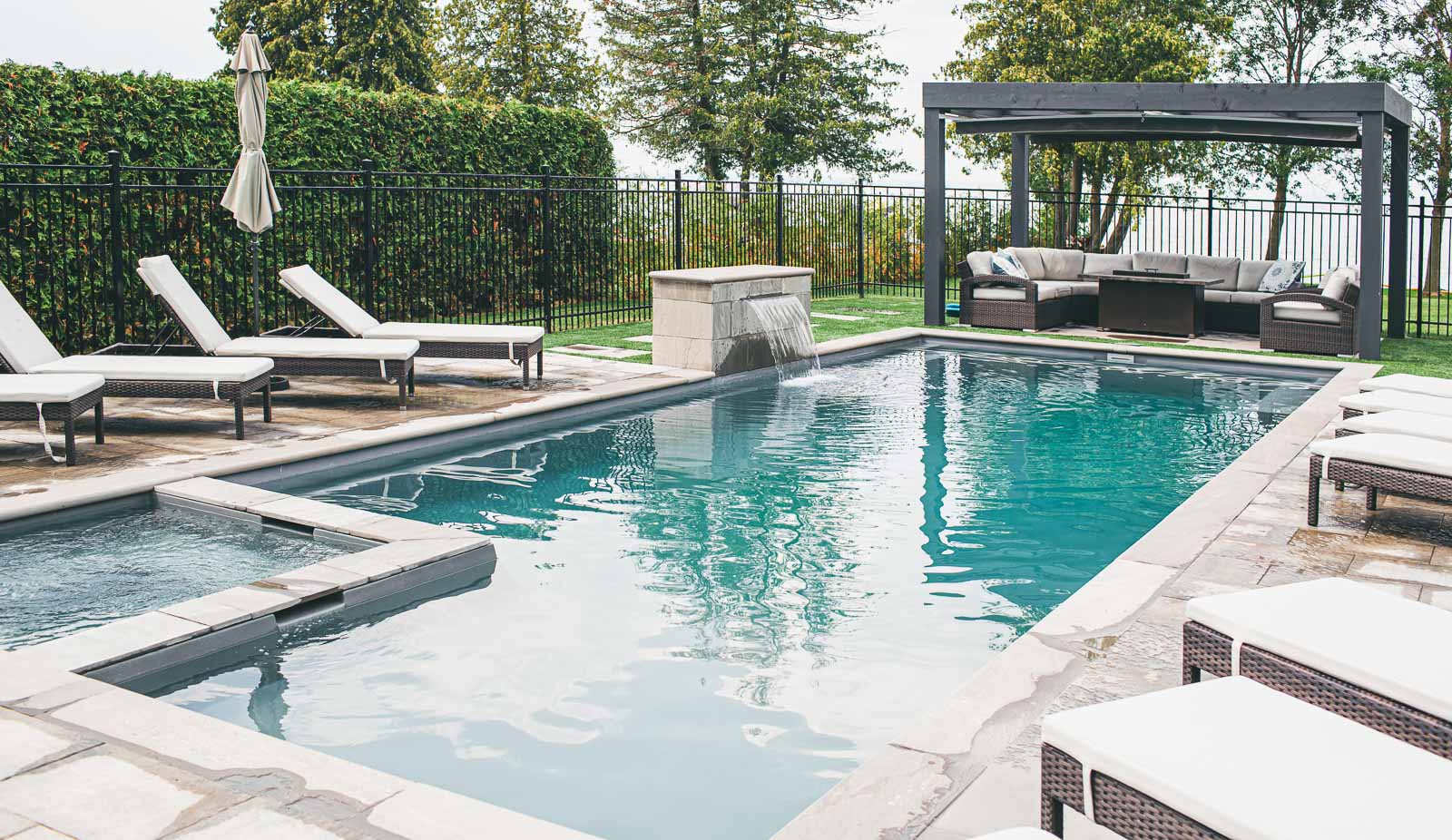 Leisure Pools Ultimate fiberglass swimming pool with built-in spa and tanning ledge