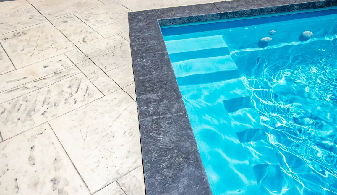 Leisure Pools Supreme composite in-ground swimming pool with bench seats in Crystal Blue