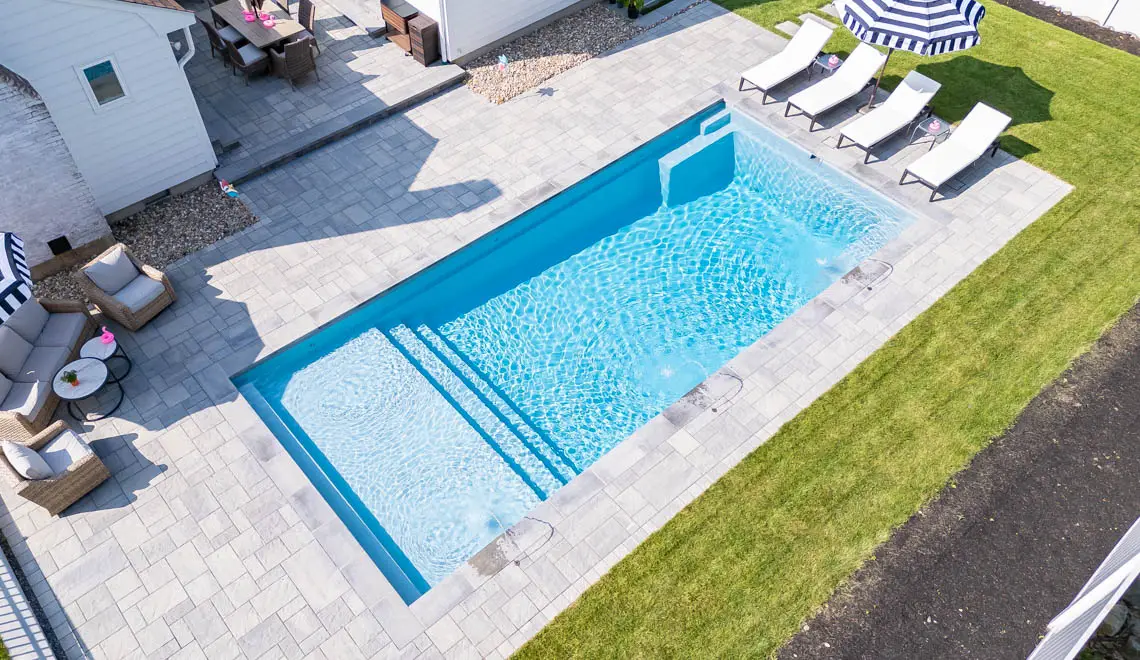 Leisure Pools Pinnacle composite fiberglass swimming pool with built-in splash deck in Silver Grey