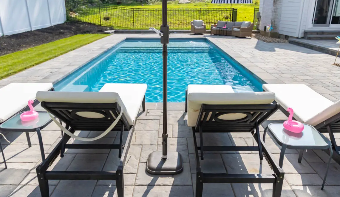 Leisure Pools Pinnacle inground fiberglass swimming pool with swim-out benches in Silver Grey