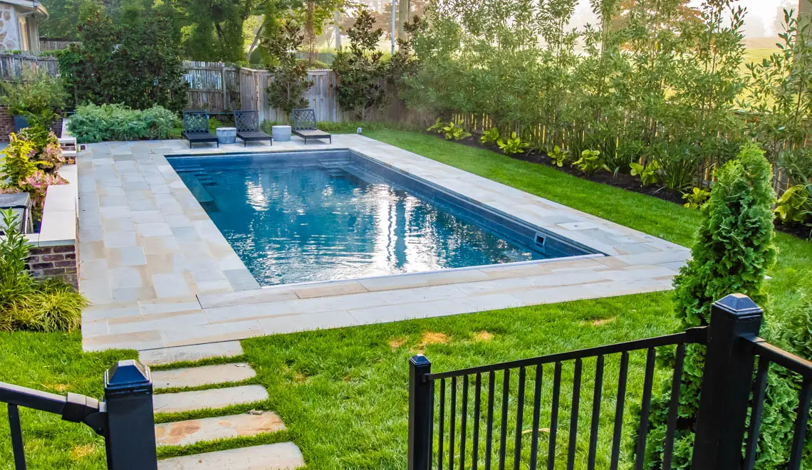 Leisure Pools Supreme composite fiberglass swimming pool with unobstructed swim channel in Graphite Grey