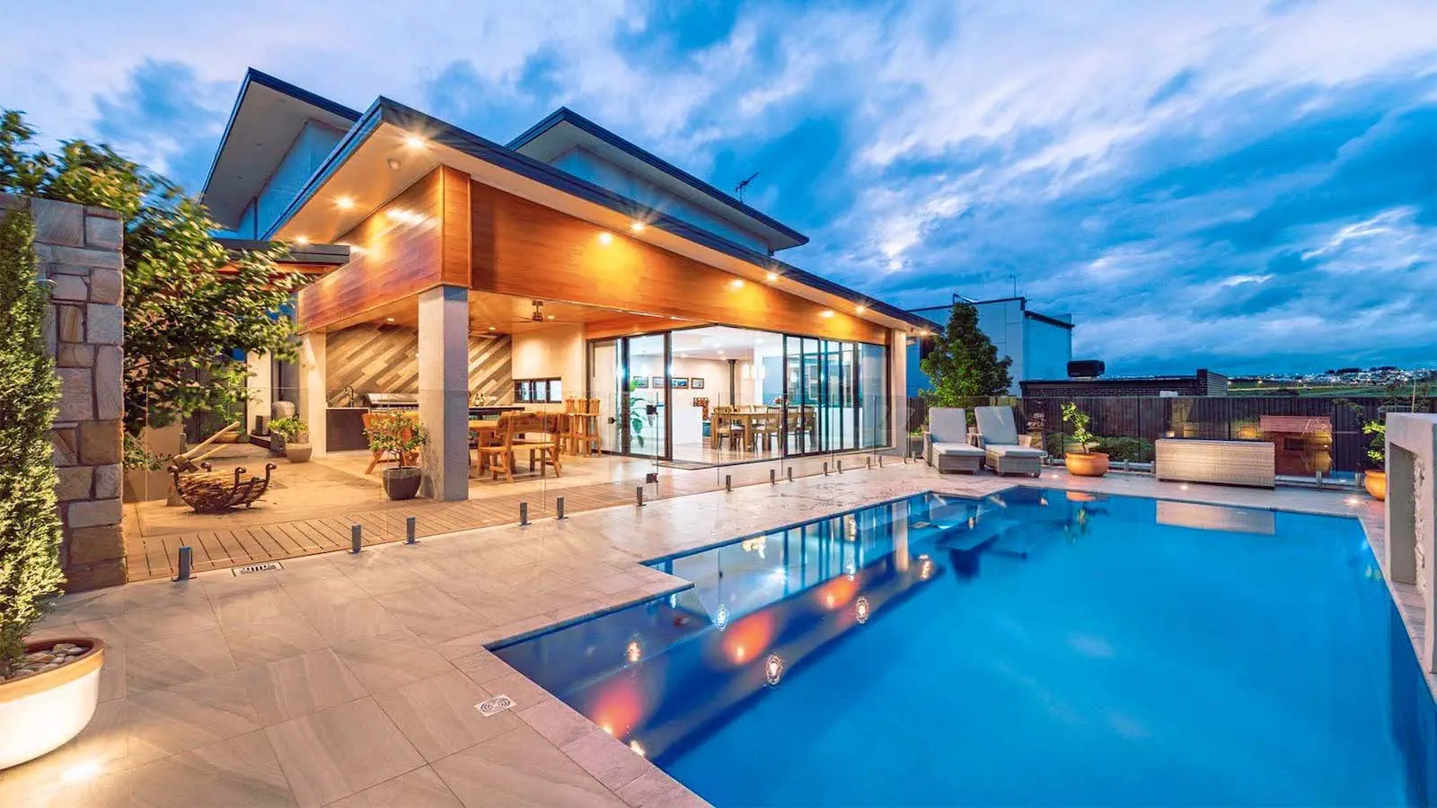 Luxury backyard showcasing The Elegance model, one of Leisure Pools USA's most popular inground fiberglass pools.